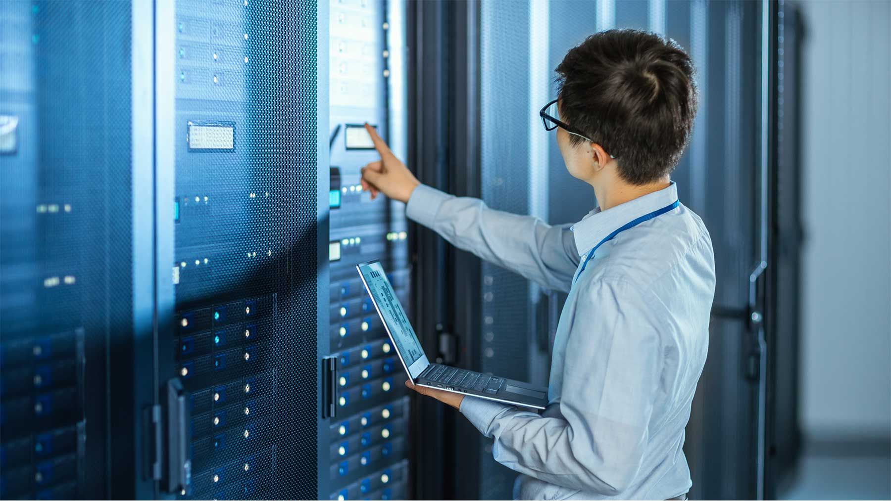 man in a server room monitoring server data