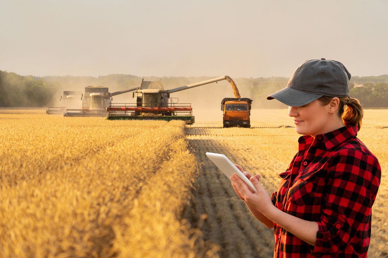 Woman in a field using IoT connectivity for smart farming equipment and monitoring