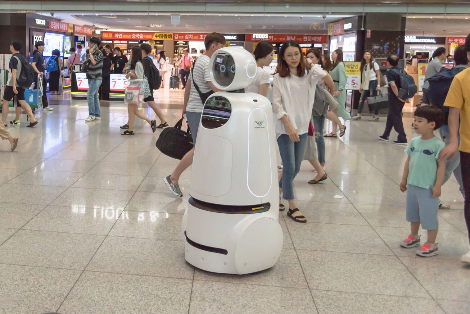 A retail robot roams in a crowded mall