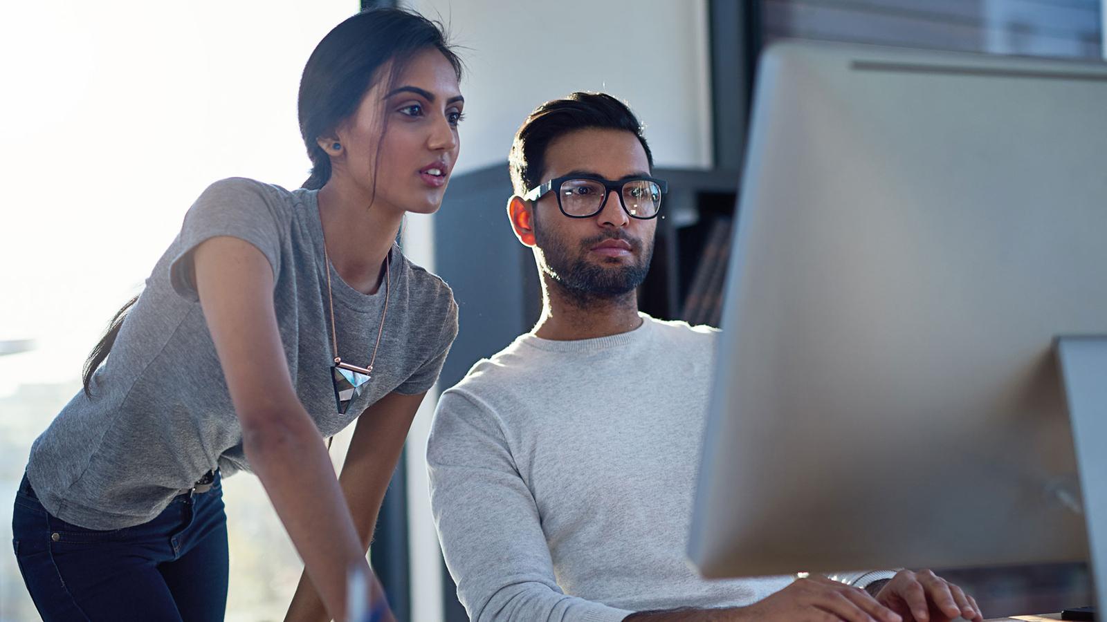Two coworkers looking at a computer