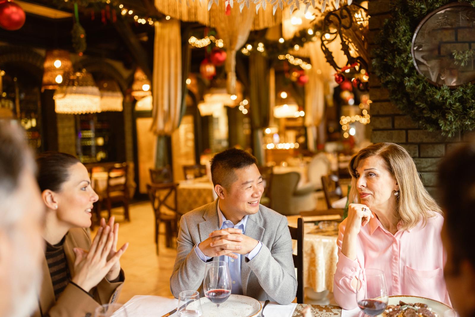 Four business people having dinner in luxury restaurant