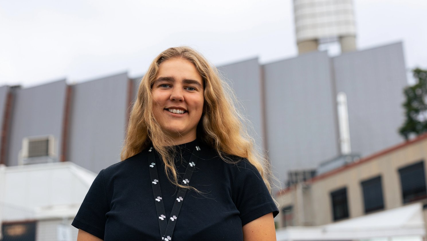 Smilende ung kvinne foran avfallsforbrenningsanlegget på Klemetsrud i Oslo.