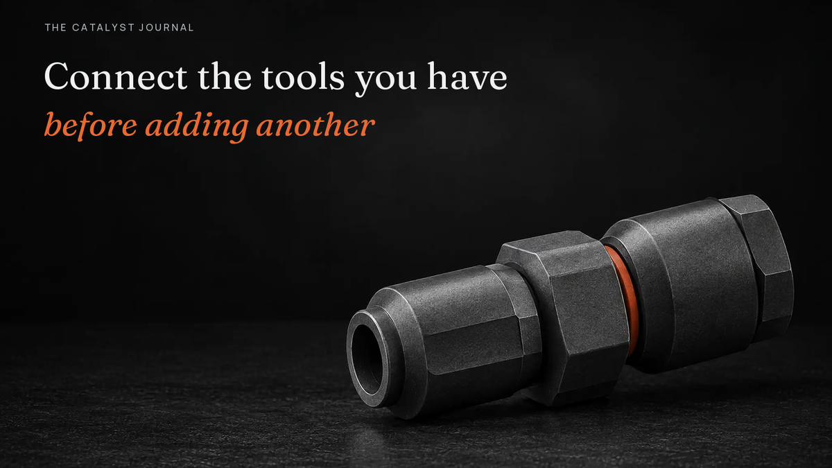 Two graphite connector housings joined by a fitted adapter and a thin terracotta gasket, showing existing tools connected rather than replaced.
