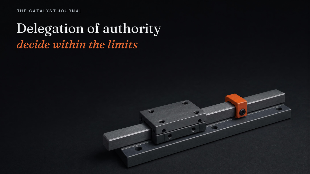 Graphite linear slide with a terracotta stop collar clamped on the rail, a delegation of authority matrix that lets work move freely up to a set limit.