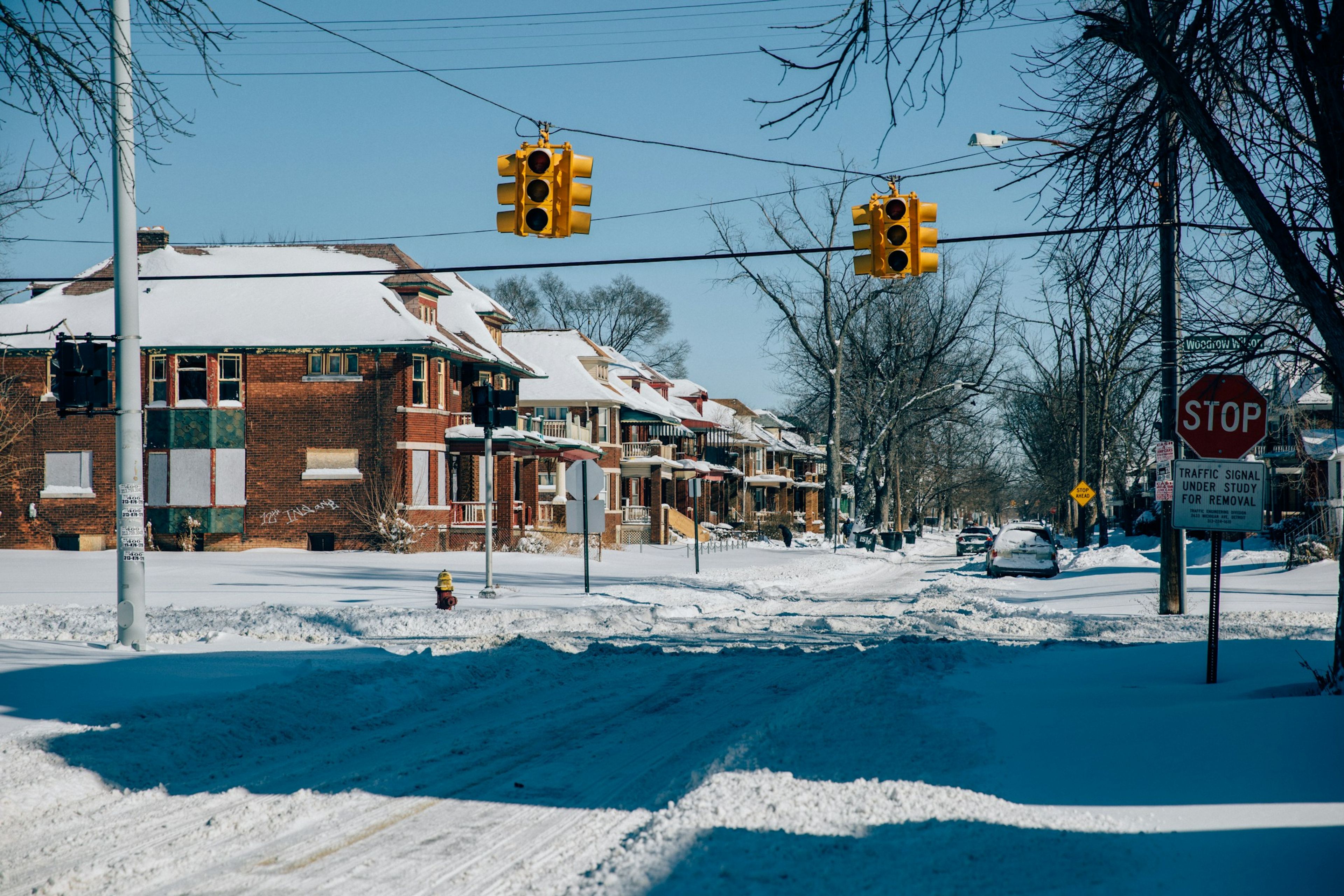 A snowy intersection under traffic lights