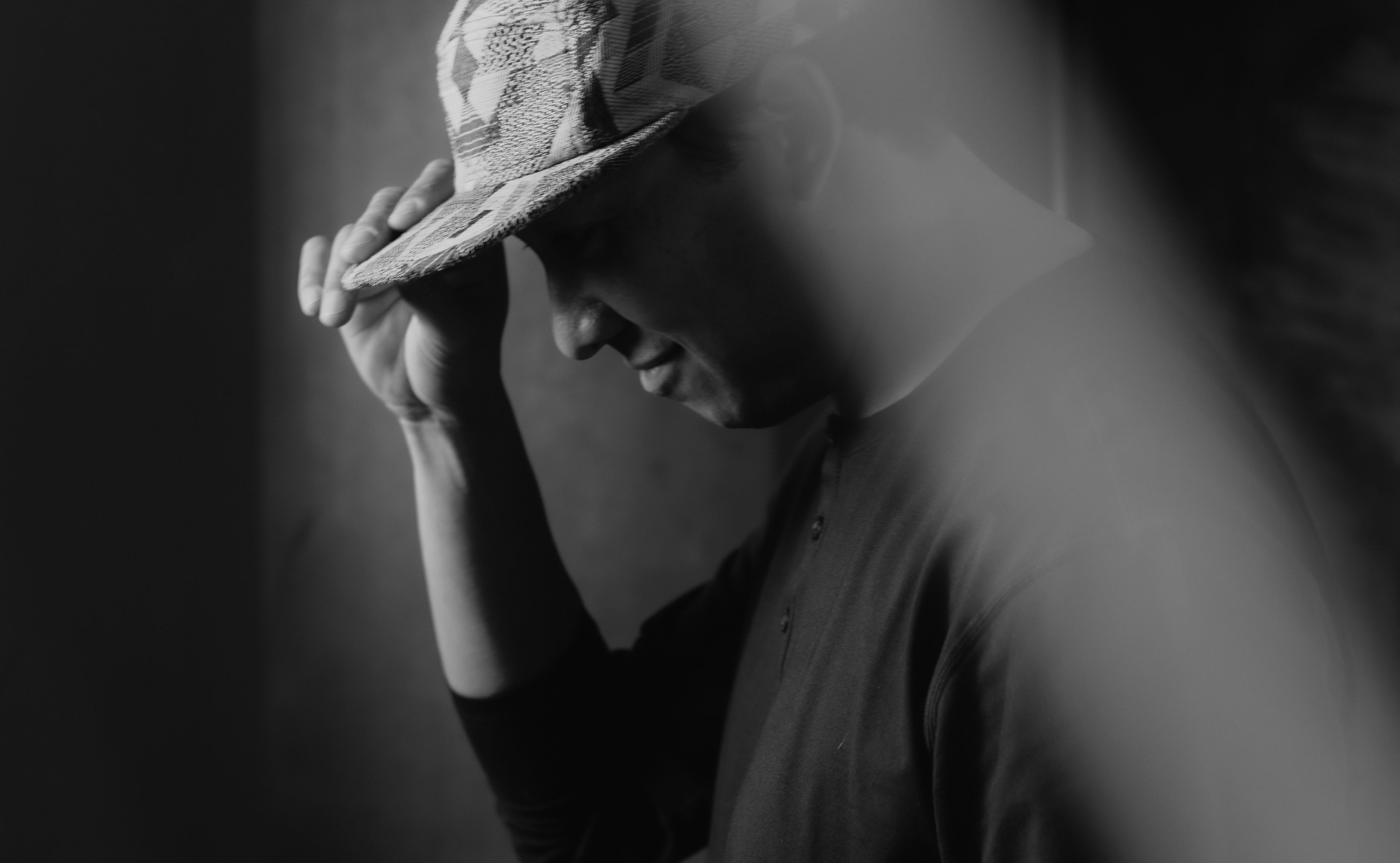 Vorrel Prendergast Jr tipping his cap, lit by a shaft of window light