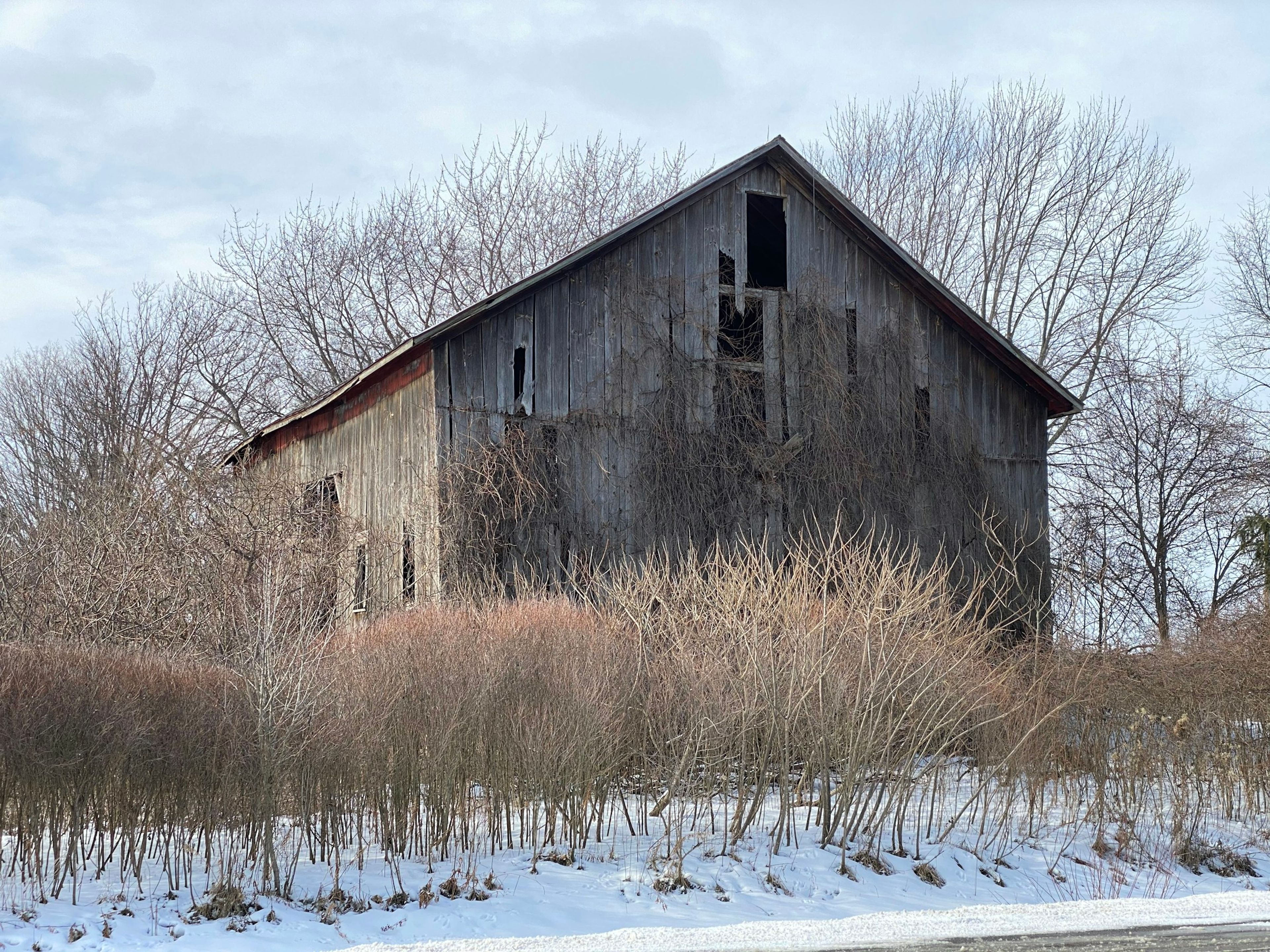 Weathered wooden barn in a snowy field