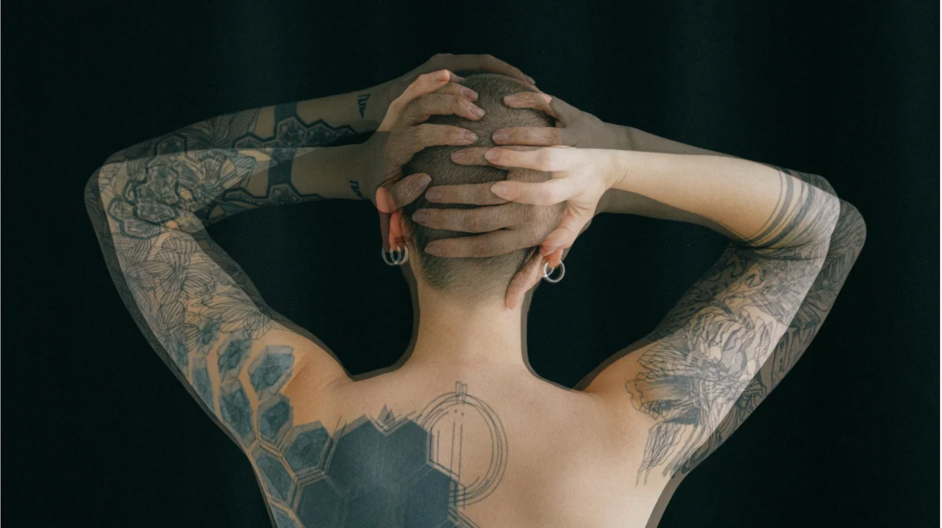 Tattooed women with hands on head