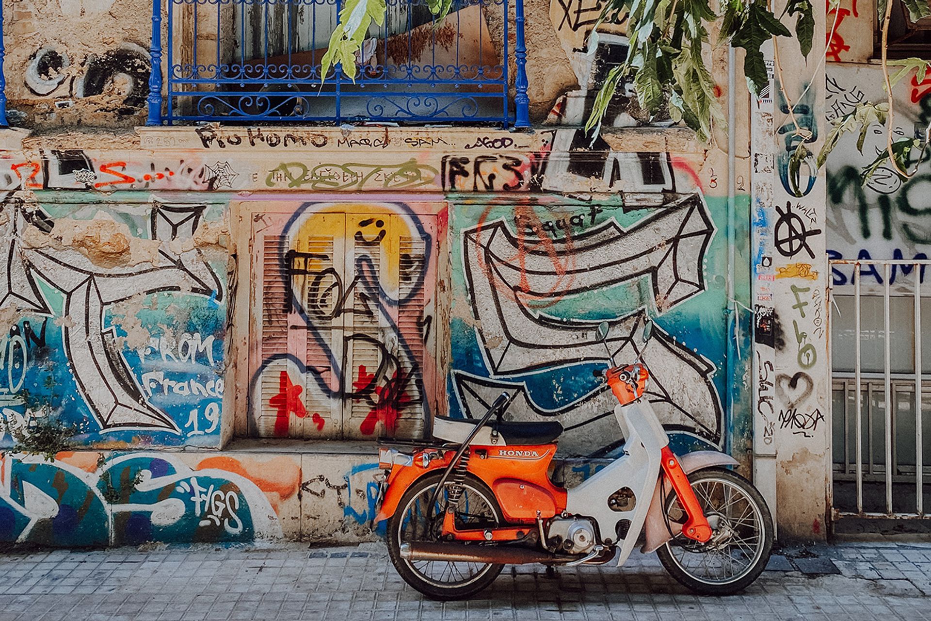A moped in front of a graffitied wall