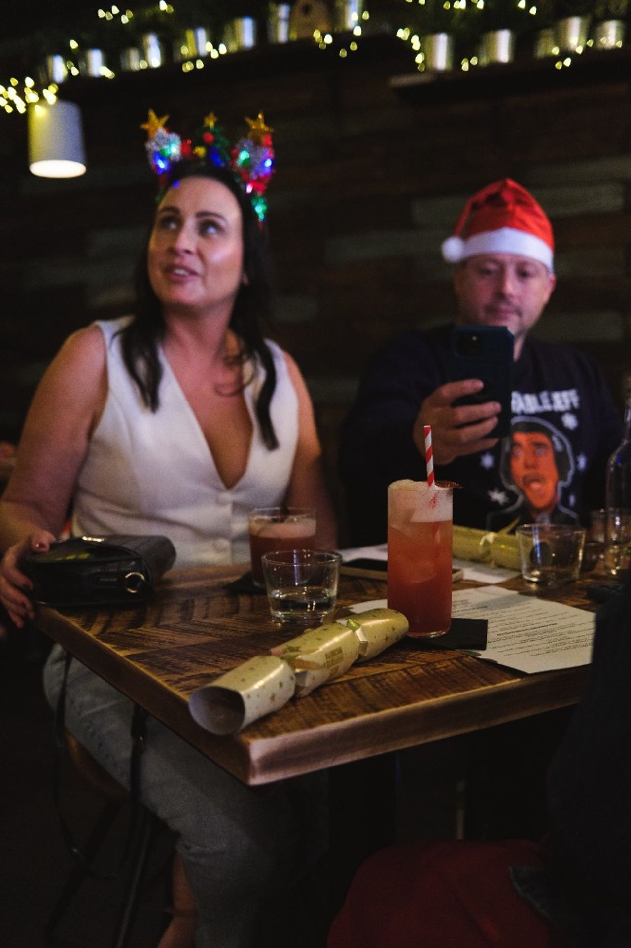 Guests at a Christmas table at The Nuthatch in Middlesbrough, with cocktails, crackers and festive drinks.