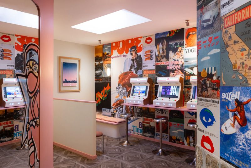 Bornes d'arcade et murs couverts d'affiches vintage dans la gaming room du Matsuri Genève
