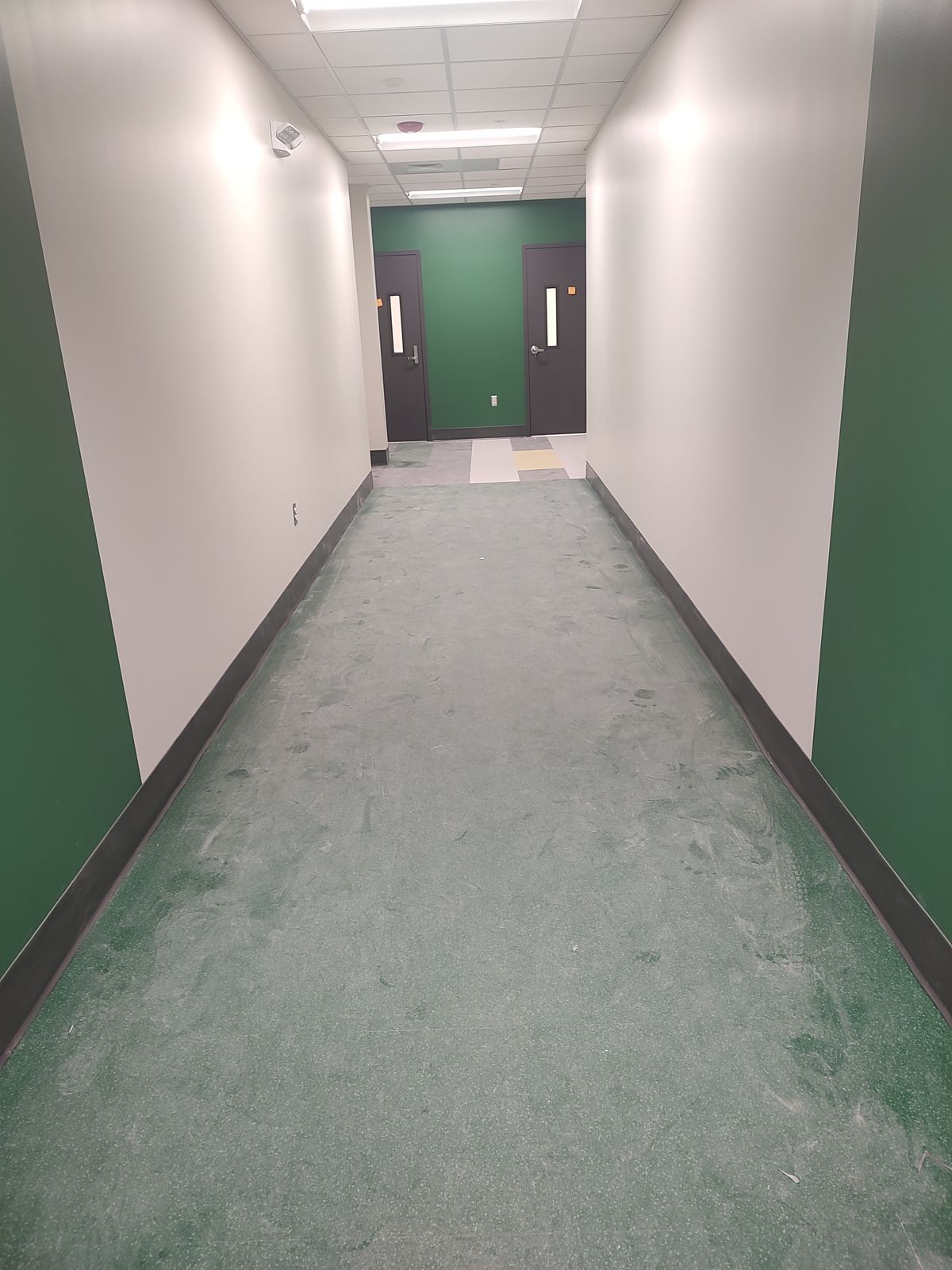 Construction dust on a hallway floor in a new school building before post-construction cleaning