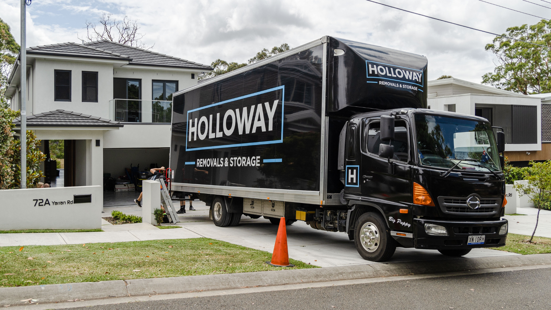 holloway removals truck in front of a house in the middle of a move