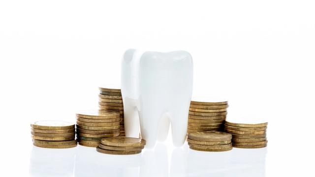an image of a tooth surrounded by gold coins