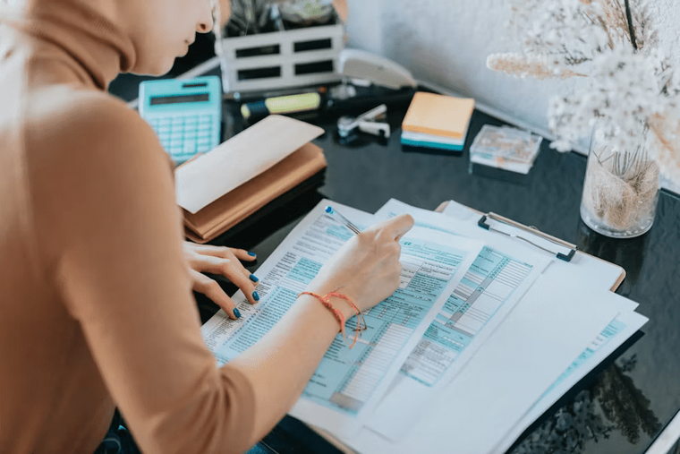 A woman focused on completing a tax form at her desk—illustrating the hands-on effort many small business owners must make when filing excise taxes with Form 720.