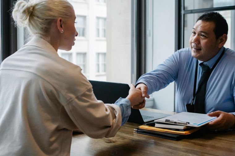 A friendly handshake between a professional and a client—highlighting the supportive role of tax advisors in helping S Corp owners navigate their tax forms.