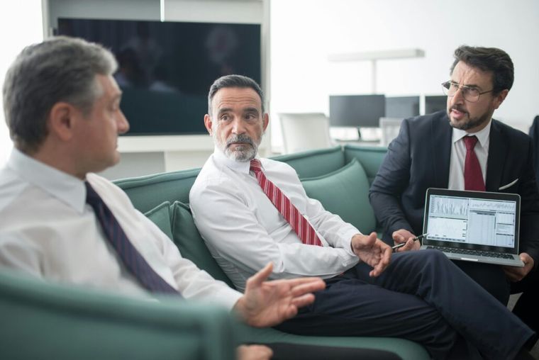 Financial advisor presenting an evergreen private equity fund strategy on a whiteboard during an investment meeting.