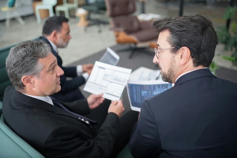Two business professionals discussing import tax strategies in an office, symbolizing accurate HTS classification and customs compliance.