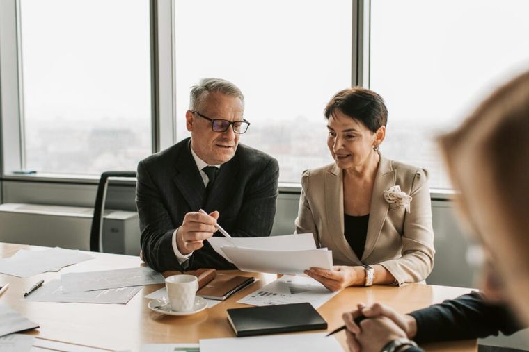 A man and woman reviewing paperwork together, representing professional tax and retirement planning advice under SECURE 2.0.