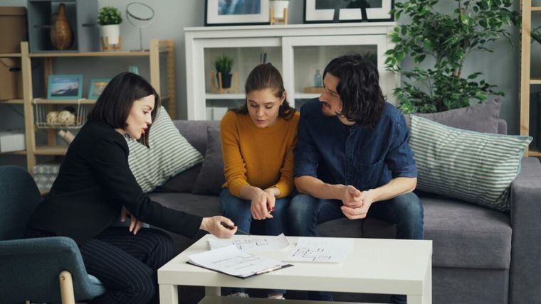 A couple meets with a real estate advisor in a modern home setting to discuss ownership structures and investment strategies.