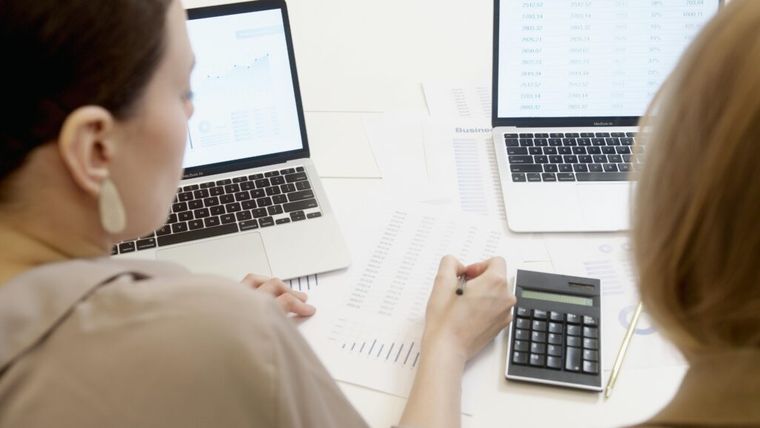 A person writing on a paper with a graph.