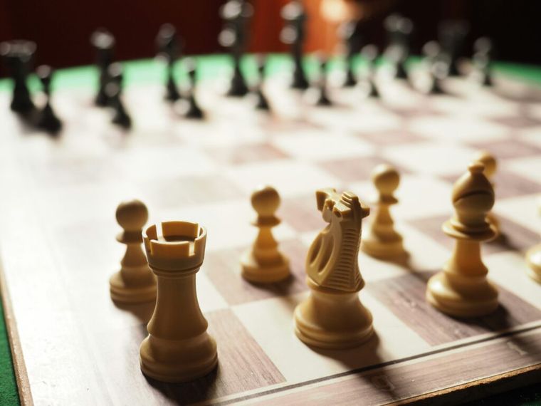 Chess pieces positioned on a board mid-game, symbolizing the strategic planning required to time a business sale effectively and minimize tax liabilities. Just like in chess, every move counts when navigating the tax implications of an exit.