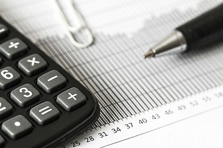 A calculator and pen resting on financial paperwork—representing the calculations expats must make to determine Foreign Earned Income Exclusion eligibility and avoid double taxation.