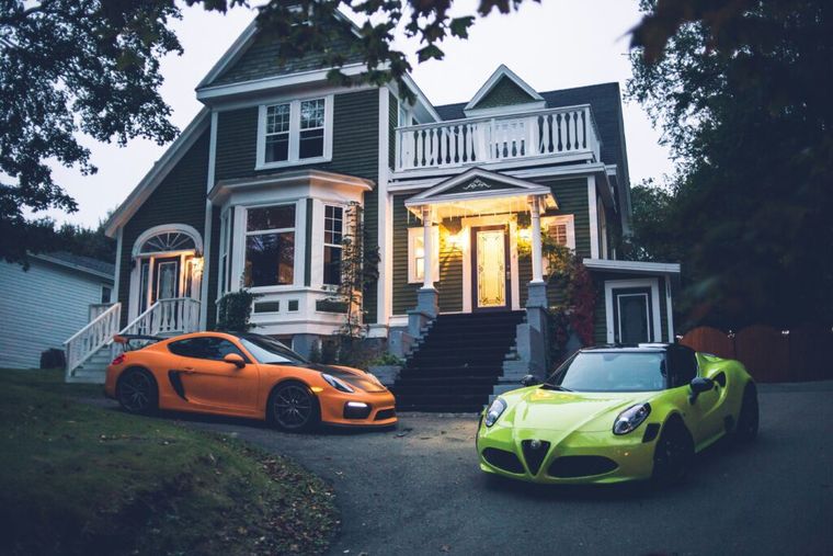 A luxury car parked in front of a modern home, symbolizing the potential rewards of successful real estate investing. The image also hints at the importance of tax planning—like avoiding the Net Investment Income Tax (NIIT)—to preserve high-value returns.}