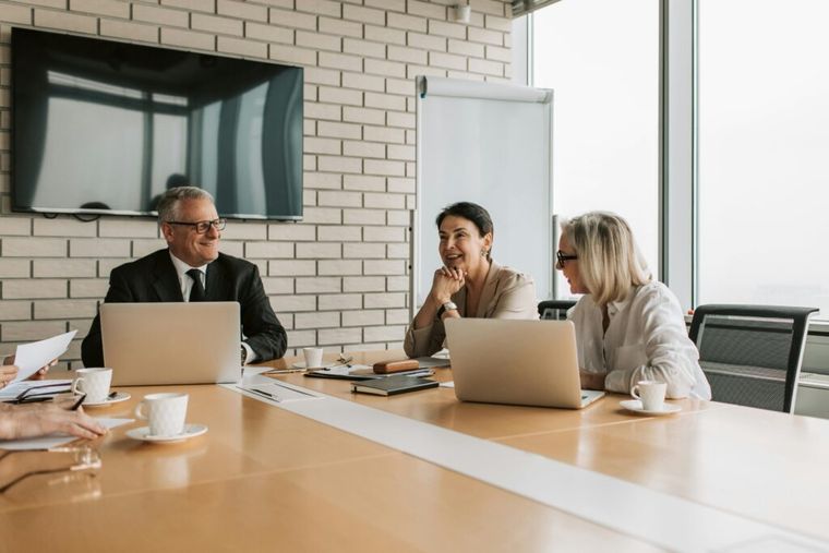 Group of professionals engaged in a meeting around a conference table, discussing strategies and ideas.
