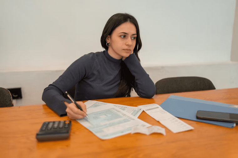 A small business owner or accountant working on a laptop, reviewing receipts or spreadsheets.