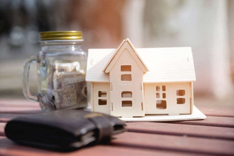 Image of a house and wallet beside each other to symbolize asset management.