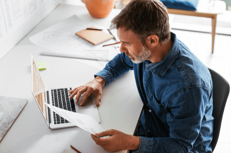 A man reviewing tax documents at his computer