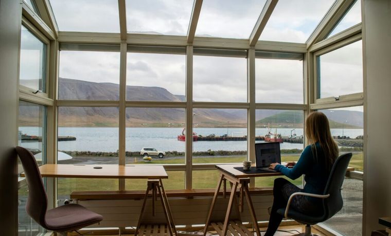 A person in a blue jacket sitting on a brown wooden chair at a wooden table, reflecting the importance of strategic planning in navigating multistate tax issues for clients.