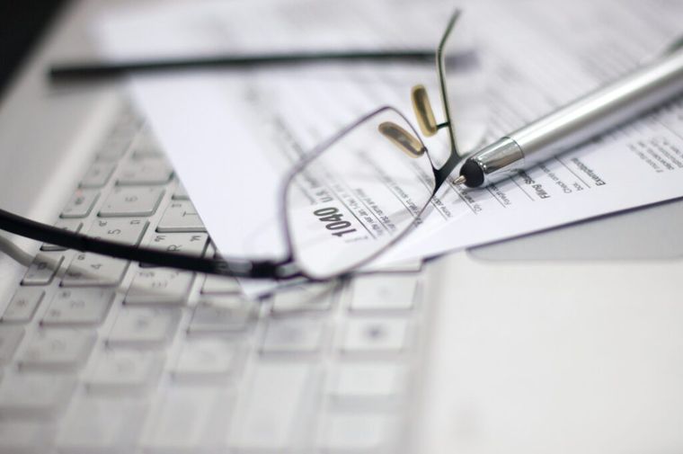Tax documents placed on a computer.