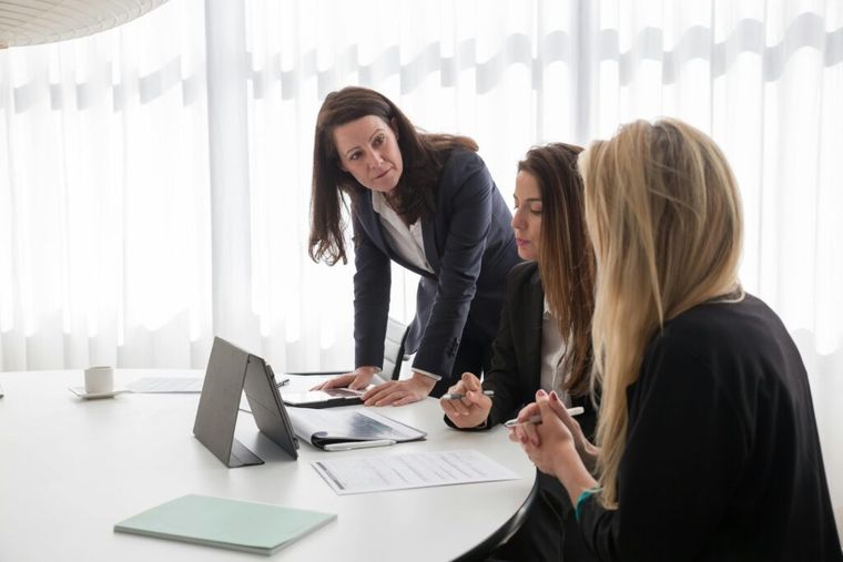 Two women in blazers collaborating in an office, symbolizing professional tax advisors providing personalized Treasury bill tax guidance.