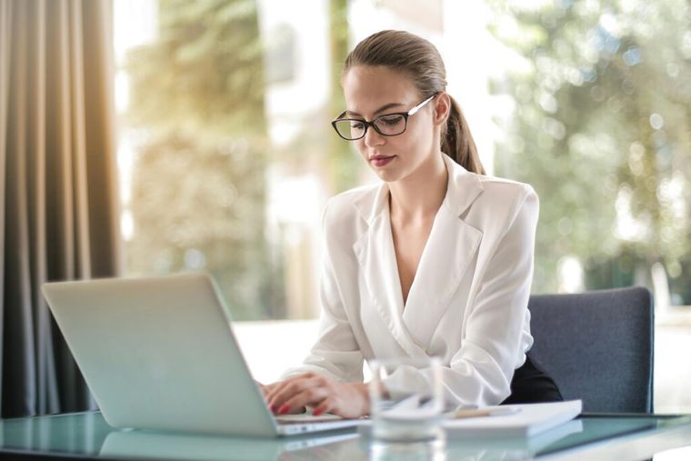 A focused entrepreneur working on a laptop at her workplace.