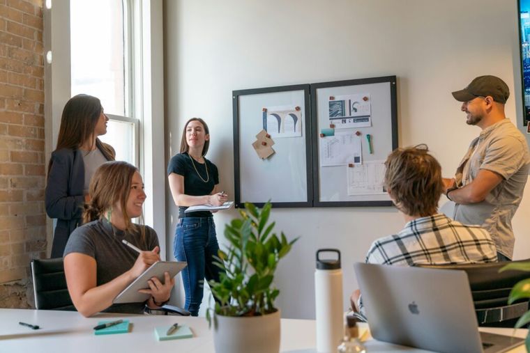 A team gathers around a conference table, actively engaged in discussion. The image represents collaborative financial planning—such as implementing deferred compensation plans—to support founders and key employees in achieving long-term tax advantages