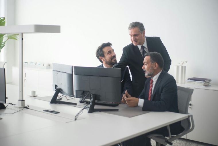 Two professionals reviewing financial documents and discussing tax loss harvesting strategies.