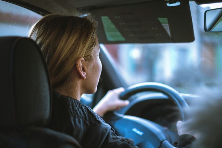 A woman driving to a work-related destination—illustrating the importance of tracking mileage and vehicle expenses to take full advantage of the 2025 IRS mileage deduction.