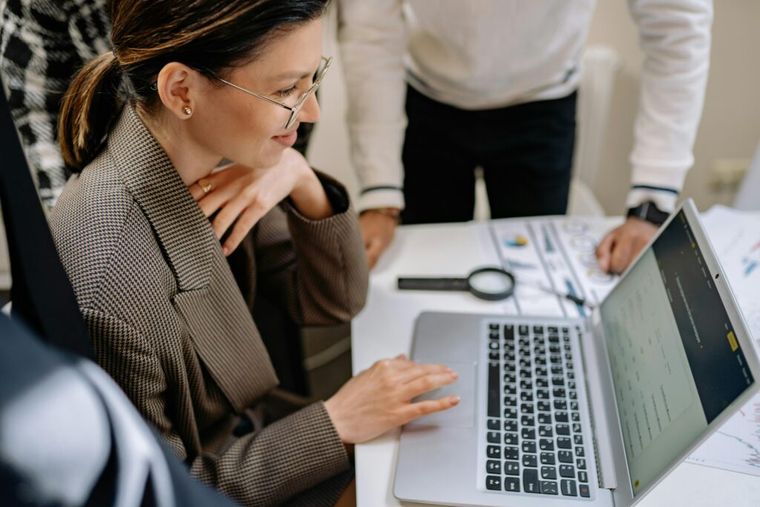 A woman sitting and using a laptop, representing the change management process.