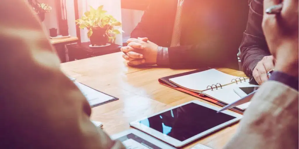 a picture of a meeting with a tablet