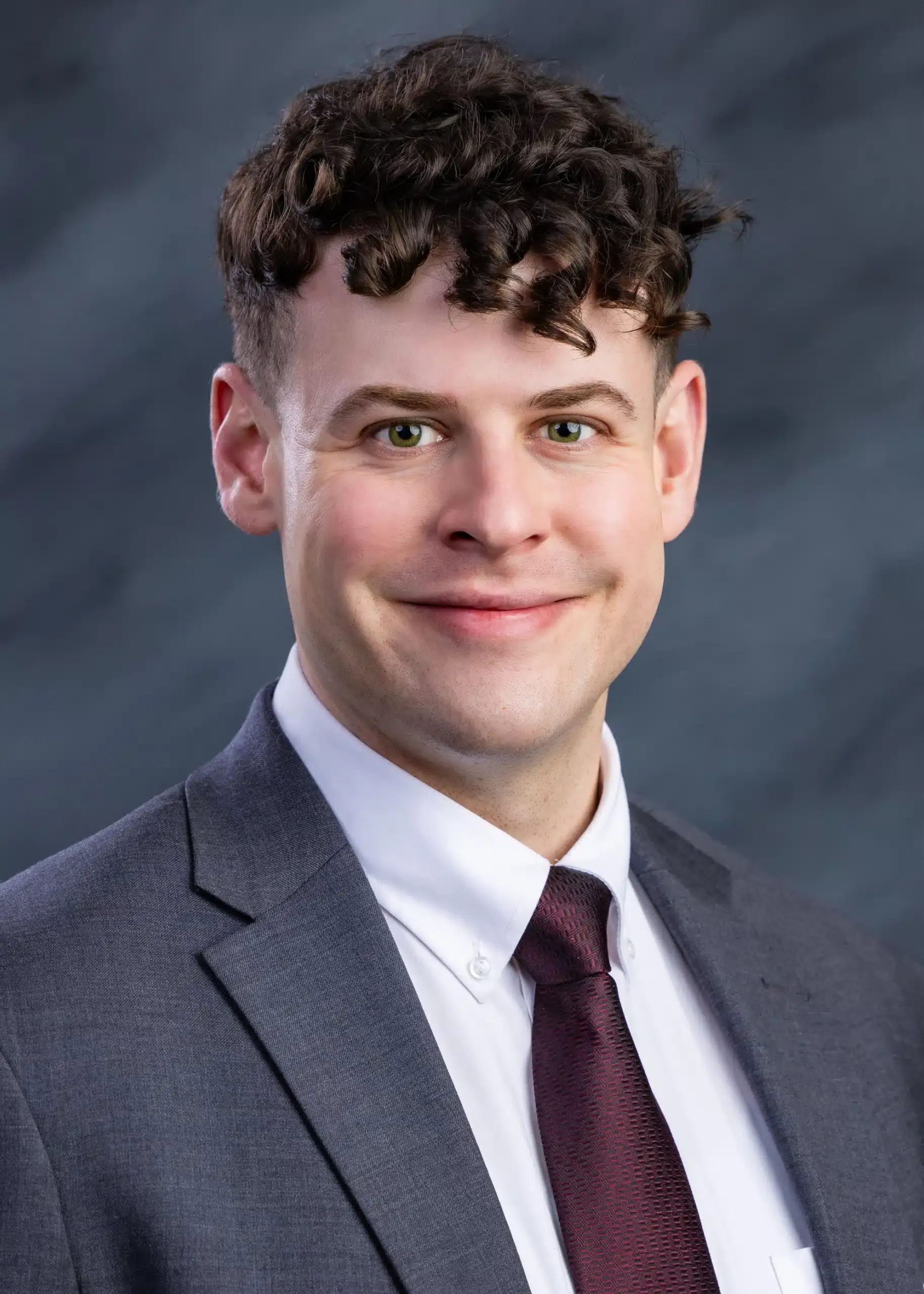 a man smiling with a curly hair