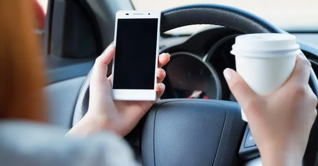 an image of a person holding a phone and a cup of coffee