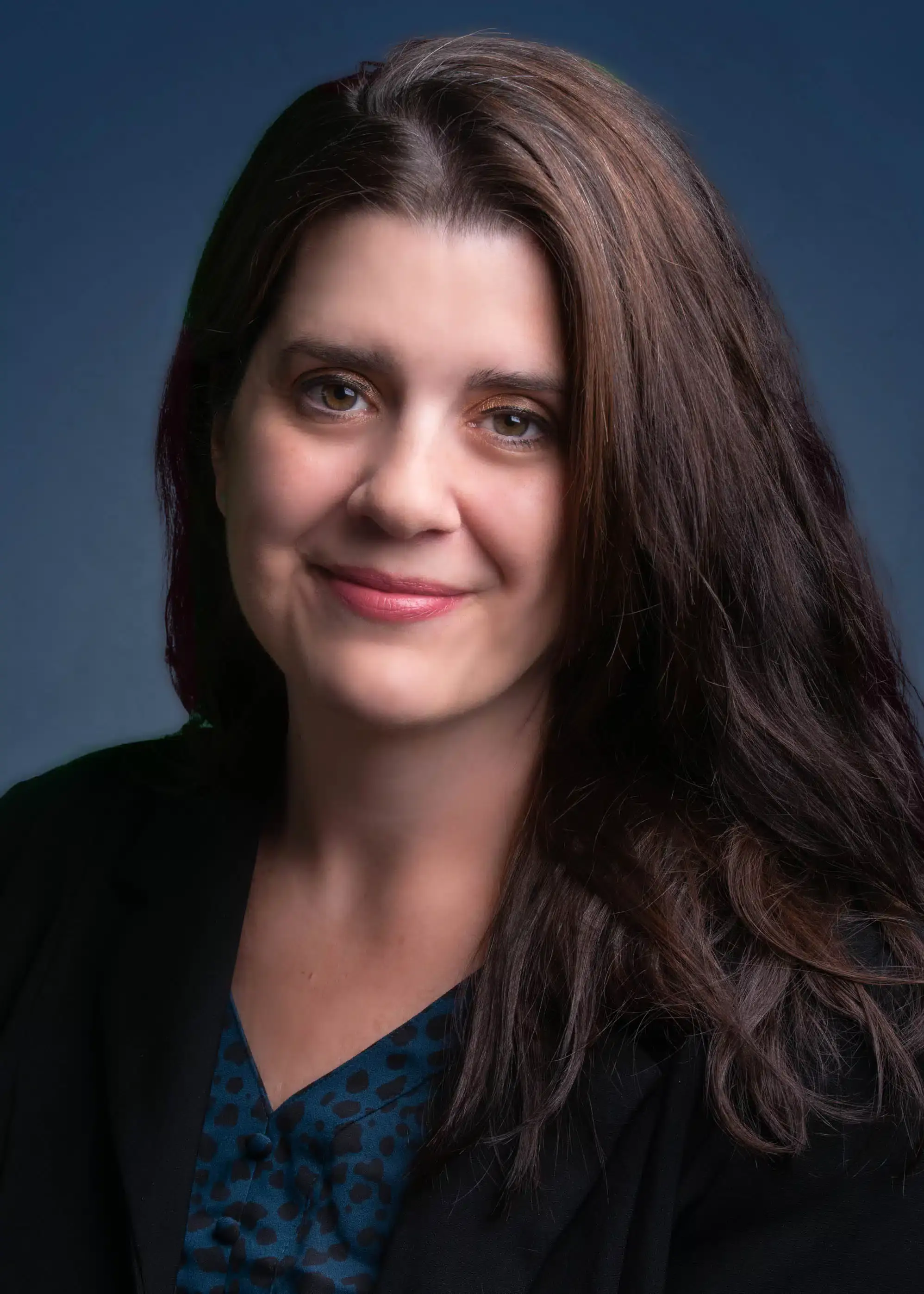a person with long brown hair smiling