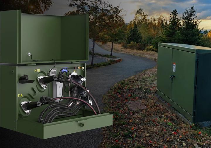Open and closed green DTM-mounted electrical transformer cabinets installed beside paved pathway