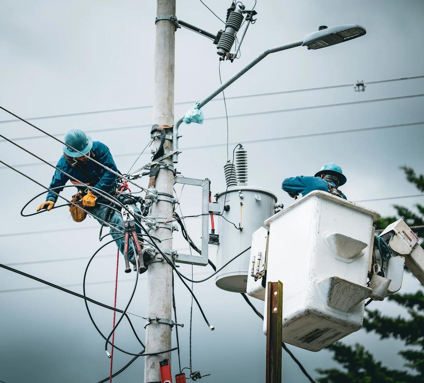 Utility crews working on power lines and streetlight equipment from bucket trucks