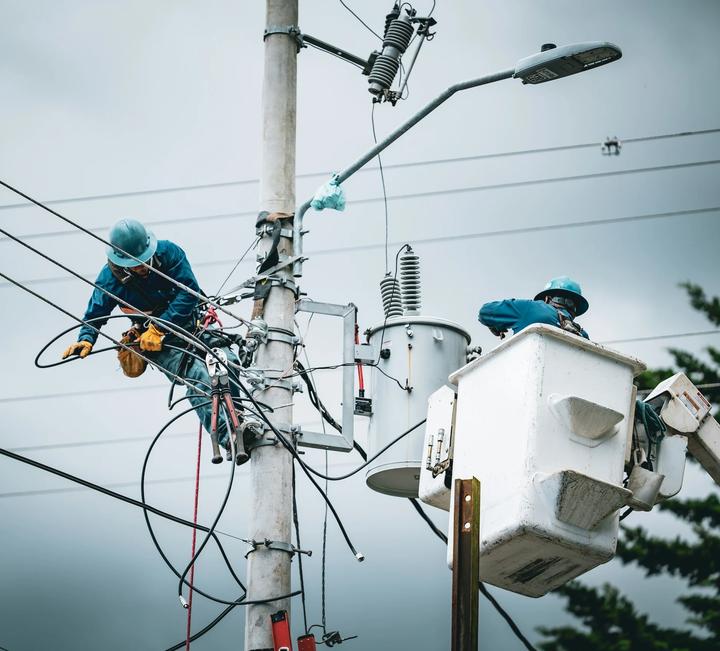 Utility crews working on power lines and streetlight equipment from bucket trucks