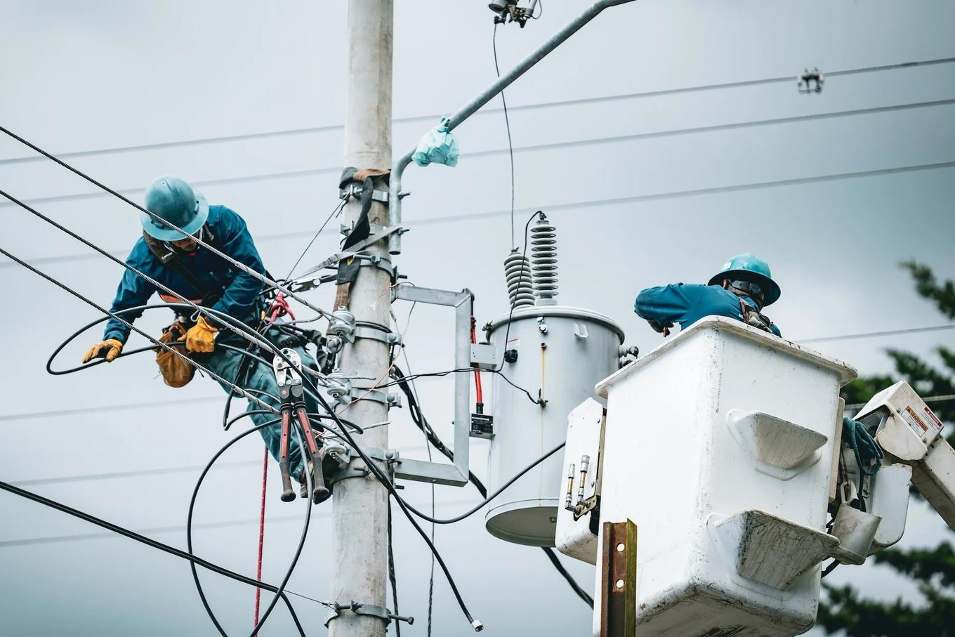 Utility crews working on power lines and streetlight equipment from bucket trucks