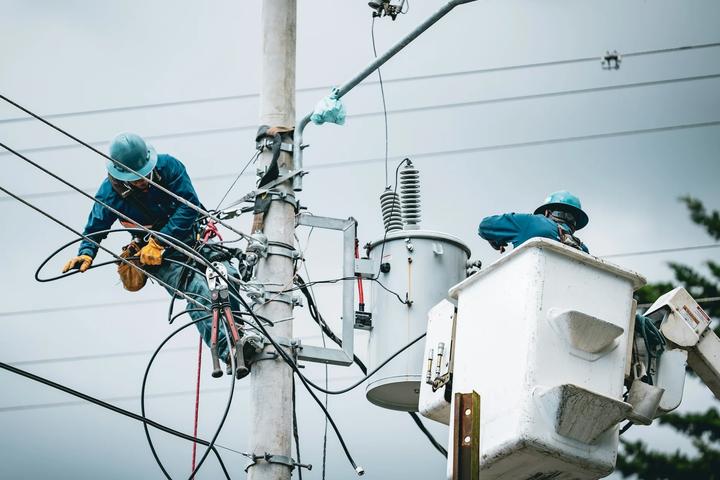 Utility crews working on power lines and streetlight equipment from bucket trucks