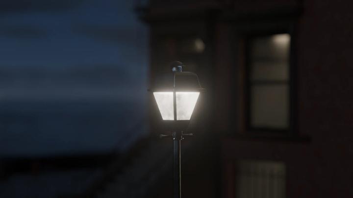 Single streetlamp illuminated at night with light diffusing through surrounding fog